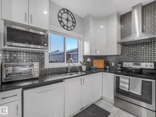 Kitchen featuring stainless steel appliances, white cabinetry, backsplash, modern cabinets, and recessed lighting - 3510 48 Avenue, Beaumont, AB - Indoor Photo Showing Kitchen With Stainless Steel Kitchen With Double Sink With Upgraded Kitchen