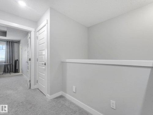 Corridor with light carpet and a textured ceiling - 3510 48 Avenue, Beaumont, AB - Indoor Photo Showing Other Room