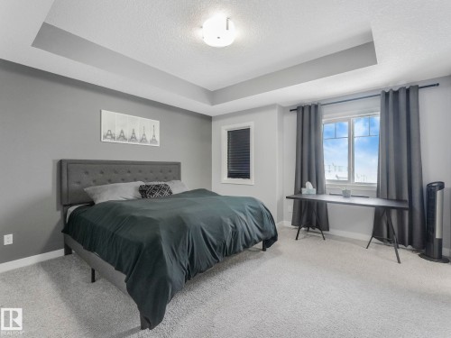 Bedroom with a tray ceiling, light carpet, and a textured ceiling - 3510 48 Avenue, Beaumont, AB - Indoor Photo Showing Bedroom
