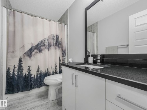 Bathroom with a textured ceiling, vanity, and light wood-style flooring - 3510 48 Avenue, Beaumont, AB - Indoor Photo Showing Bathroom