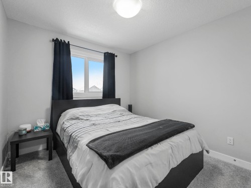 Carpeted bedroom with baseboards and a textured ceiling - 3510 48 Avenue, Beaumont, AB - Indoor Photo Showing Bedroom