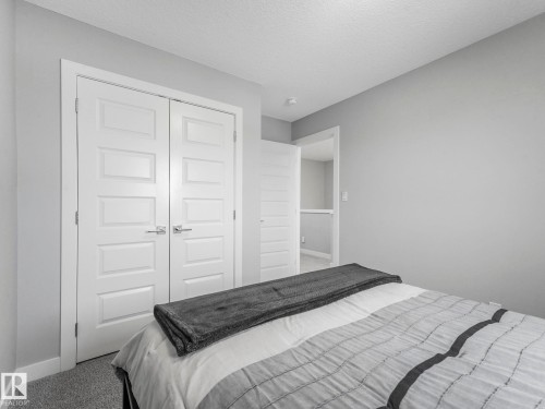 Carpeted bedroom featuring a textured ceiling and a closet - 3510 48 Avenue, Beaumont, AB - Indoor Photo Showing Bedroom