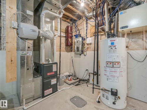 Utility room with heating unit, water heater, and electric panel - 3510 48 Avenue, Beaumont, AB - Indoor Photo Showing Basement
