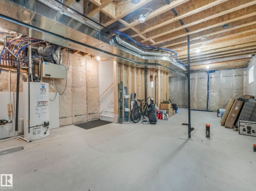Unfinished basement featuring water heater - 3510 48 Avenue, Beaumont, AB - Indoor Photo Showing Basement