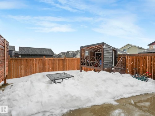 Yard layered in snow with a fenced backyard, a residential view, and a deck - 3510 48 Avenue, Beaumont, AB - Outdoor