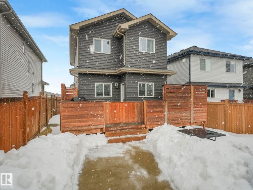 Snow covered rear of property featuring a fenced backyard and a deck - 3510 48 Avenue, Beaumont, AB - Outdoor