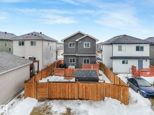 Snow covered house featuring a residential view and a fenced backyard - 3510 48 Avenue, Beaumont, AB - Outdoor With Deck Patio Veranda