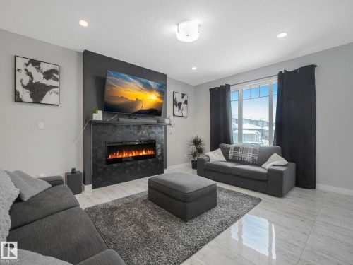 Living area with a tile fireplace and recessed lighting - 3510 48 Avenue, Beaumont, AB - Indoor Photo Showing Living Room With Fireplace