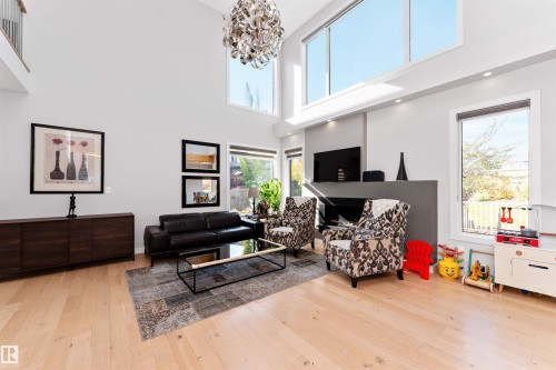 Living area with light wood-style flooring, a chandelier, and a high ceiling - 7404 May Common, Edmonton, AB - Indoor