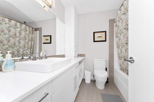 Bathroom with vanity, light tile patterned floors, and shower / bath combination with curtain - 7404 May Common, Edmonton, AB - Indoor Photo Showing Bathroom