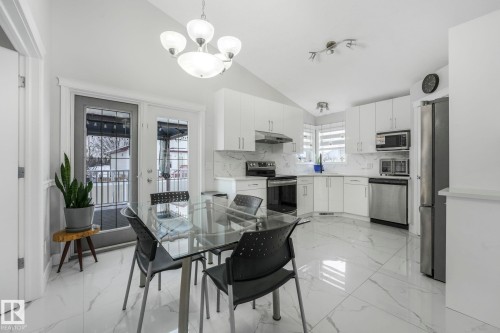 Dining room featuring lofted ceiling, suspended lighting, and light marble finish floors - 2919 151A Avenue, Edmonton, AB - Indoor