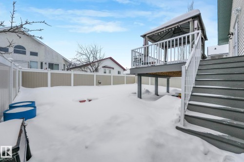 Yard layered in snow with a fenced backyard and a wooden deck - 2919 151A Avenue, Edmonton, AB - Outdoor