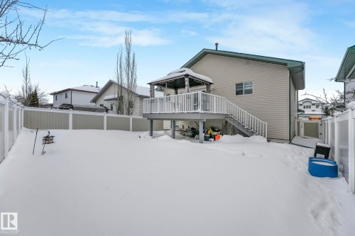 Snow covered rear of property featuring a fenced backyard and a wooden deck - 2919 151A Avenue, Edmonton, AB - Outdoor With Deck Patio Veranda