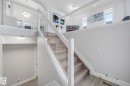 Stairway with wood finished floors and hanging lights - 2919 151A Avenue, Edmonton, AB  - Indoor Photo Showing Other Room 