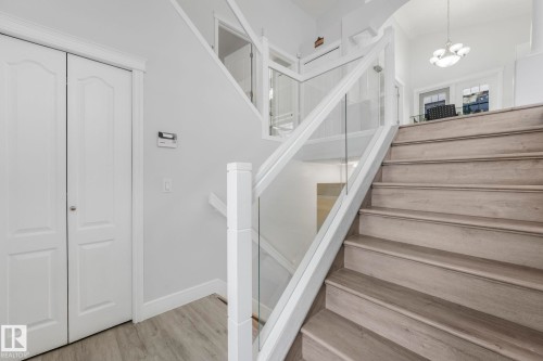 Staircase featuring wood finished floors and suspended lighting - 2919 151A Avenue, Edmonton, AB - Indoor Photo Showing Other Room