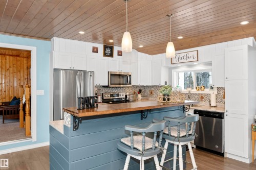 Dining space featuring a vaulted wooden ceiling, recessed lighting, wood finished floors, a wood stove, and crown molding - 516 5 Street, Rural Lac Ste. Anne County, AB - Indoor Photo Showing Dining Room