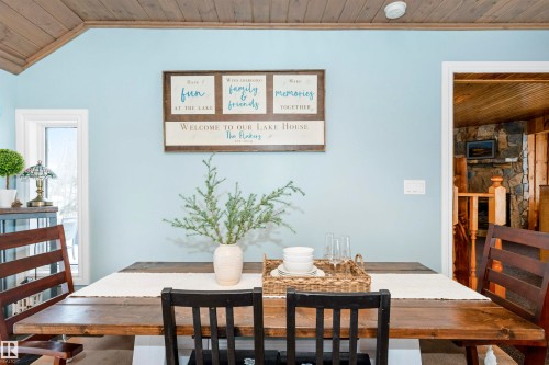 Kitchen with white cabinets, a breakfast bar, wooden counters, decorative light fixtures, and stainless steel appliances - 516 5 Street, Rural Lac Ste. Anne County, AB - Indoor