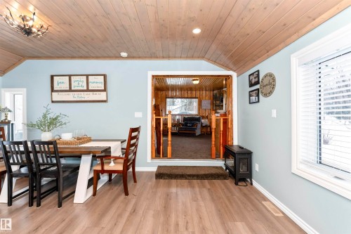 Living area featuring healthy amount of natural light, carpet flooring, wooden ceiling, and wooden walls - 516 5 Street, Rural Lac Ste. Anne County, AB - Indoor Photo Showing Living Room