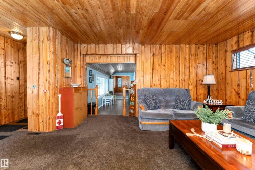 Carpeted bedroom featuring wooden walls - 516 5 Street, Rural Lac Ste. Anne County, AB - Indoor Photo Showing Bedroom