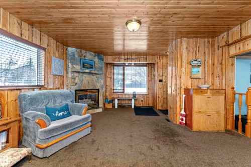 Bedroom featuring carpet flooring, wood walls, and ensuite bathroom - 516 5 Street, Rural Lac Ste. Anne County, AB - Indoor
