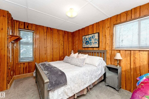 Bathroom featuring wooden walls, shower / bath combination with curtain, and carpet flooring - 516 5 Street, Rural Lac Ste. Anne County, AB - Indoor Photo Showing Other Room