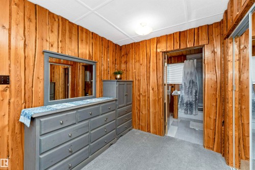 Bedroom with carpet floors and wooden walls - 516 5 Street, Rural Lac Ste. Anne County, AB - Indoor Photo Showing Bedroom