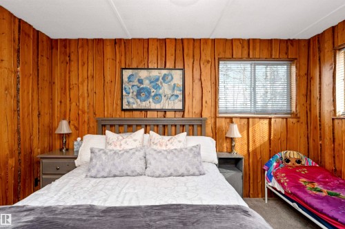 Bedroom with light carpet and wooden walls - 516 5 Street, Rural Lac Ste. Anne County, AB - Indoor Photo Showing Bedroom