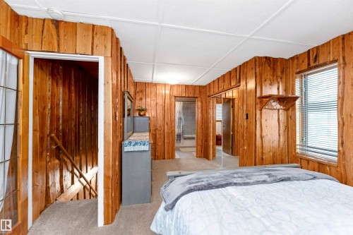 Bathroom featuring wooden walls, shower / bathtub combination with curtain, light tile patterned floors, and wood ceiling - 516 5 Street, Rural Lac Ste. Anne County, AB - Indoor Photo Showing Bathroom