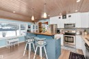 Kitchen featuring stainless steel appliances, white cabinets, a vaulted wooden ceiling, decorative light fixtures, and decorative backsplash - 516 5 Street, Rural Lac Ste. Anne County, AB  - Indoor Photo Showing Kitchen 