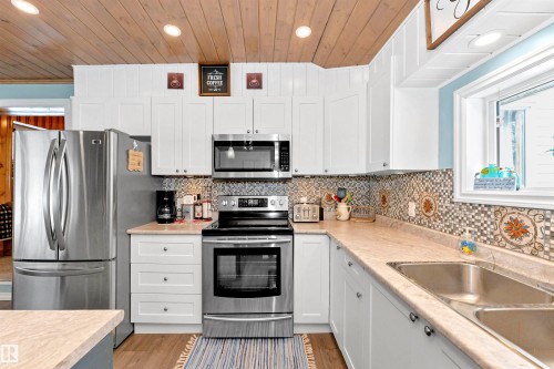 Kitchen featuring stainless steel appliances, white cabinets, wood ceiling, and recessed lighting - 516 5 Street, Rural Lac Ste. Anne County, AB - Indoor Photo Showing Kitchen