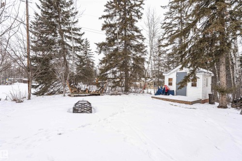 Yard covered in snow featuring a deck, an outbuilding, and a fire pit - 516 5 Street, Rural Lac Ste. Anne County, AB - Outdoor