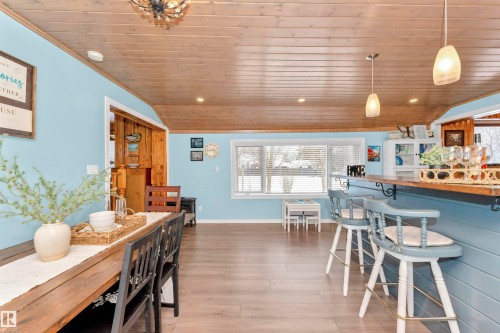 Dual tone kitchen with a breakfast bar, decorative light fixtures, a kitchen island, stainless steel appliances, and two tone cabinetry - 516 5 Street, Rural Lac Ste. Anne County, AB - Indoor