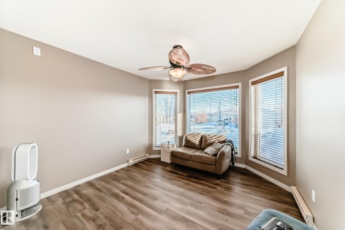 Living area featuring wood finished floors, ceiling fan, a baseboard radiator, and baseboard heating - 2927 30 Street, Edmonton, AB - Indoor