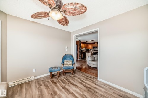 Sitting room with a baseboard radiator, a ceiling fan, and light wood-style flooring - 2927 30 Street, Edmonton, AB - Indoor