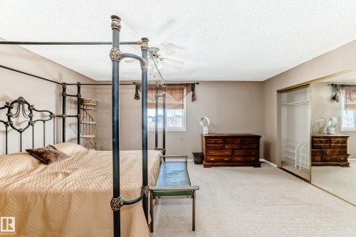 Bedroom featuring a textured ceiling, a closet, carpet, and ceiling fan - 2927 30 Street, Edmonton, AB - Indoor