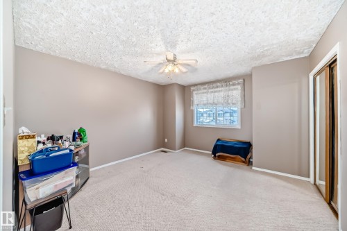 Carpeted bedroom featuring a textured ceiling and a ceiling fan - 2927 30 Street, Edmonton, AB - Indoor Photo Showing Other Room