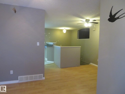 Unfurnished room with light wood finished floors, a ceiling fan, and a textured ceiling - 1855 Mill Woods Road E, Edmonton, AB - Indoor Photo Showing Other Room