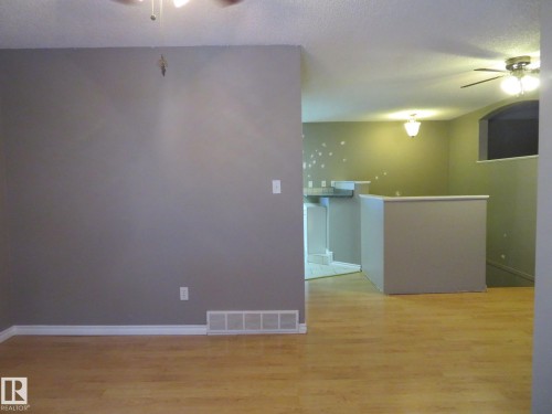 Spare room with a ceiling fan, light wood-type flooring, and a textured ceiling - 1855 Mill Woods Road E, Edmonton, AB - Indoor Photo Showing Other Room