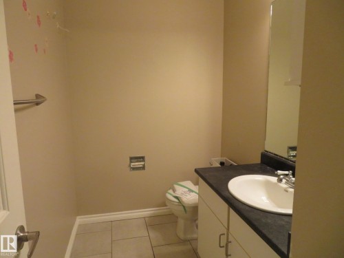 Half bathroom with vanity and light tile patterned floors - 1855 Mill Woods Road E, Edmonton, AB - Indoor Photo Showing Bathroom
