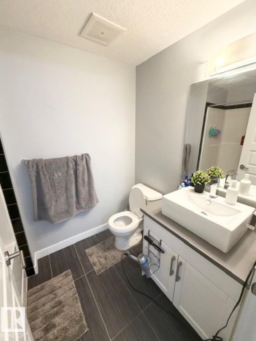 Full bathroom featuring vanity, an enclosed shower, and a textured ceiling - 706 5151 Windermere Bv, Edmonton, AB - Indoor Photo Showing Bathroom