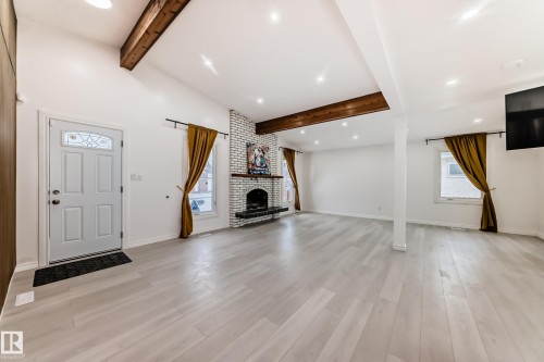 Unfurnished living room featuring recessed lighting, lofted ceiling with beams, light wood-style floors, and a fireplace - 10519 173 Avenue, Edmonton, AB - Indoor With Fireplace