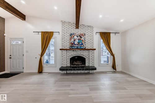 Living area with vaulted ceiling with beams, a fireplace, and light wood-style floors - 10519 173 Avenue, Edmonton, AB - Indoor With Fireplace