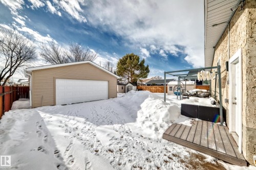 Yard covered in snow with an outdoor structure, a fenced backyard, and a detached garage - 10519 173 Avenue, Edmonton, AB - Outdoor