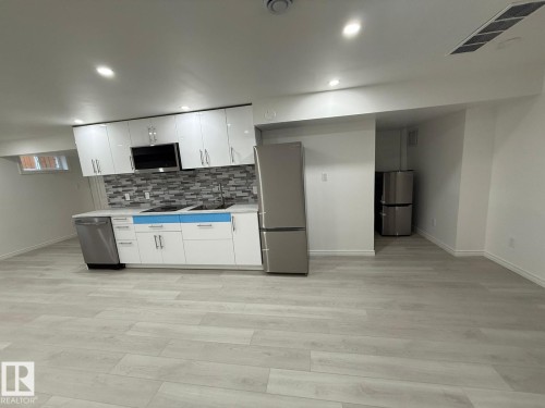Kitchen featuring white cabinets, light countertops, stainless steel appliances, recessed lighting, and light wood finished floors - 10519 173 Avenue, Edmonton, AB - Indoor Photo Showing Kitchen