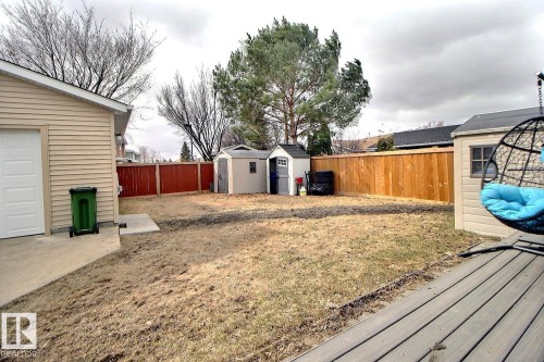 Expansive backyard featuring a new wood fence and two storage sheds - 10519 173 Avenue, Edmonton, AB - Outdoor