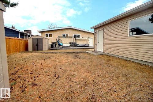 Rear exterior featuring tan horizontal siding and a large window - 10519 173 Avenue, Edmonton, AB - Outdoor With Deck Patio Veranda With Exterior