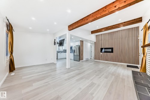 Unfurnished living room with recessed lighting, beamed ceiling, light wood finished floors, and a fireplace - 10519 173 Avenue, Edmonton, AB - Indoor With Fireplace