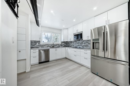Kitchen with stainless steel appliances, white cabinets, recessed lighting, and tasteful backsplash - 10519 173 Avenue, Edmonton, AB - Indoor Photo Showing Kitchen With Upgraded Kitchen
