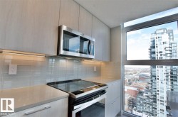 Kitchen featuring appliances with stainless steel finishes, modern cabinets, a city view, and light stone counters - 