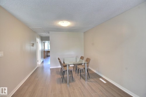 Dining area with a textured ceiling and wood finish floors - 11512 67 Street, Edmonton, AB - Indoor Photo Showing Dining Room